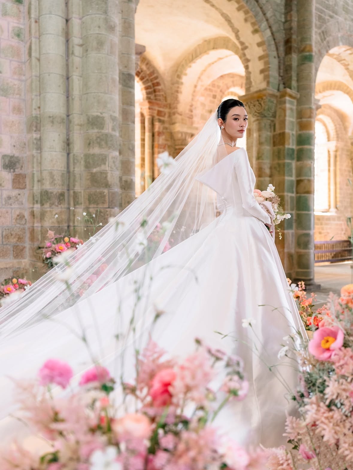 For her wedding to entrepreneur Mario Ho @momomarioho , model Ming Xi @mingxi11 chose a custom haute couture wedding gown by @dior . From the very beginning of her wedding planning journey, she knew one of her first appointments had to be with the storied French fashion house, long one of her favorites. During her initial fitting, fate intervened: Jonathan Anderson was in the atelier developing his inaugural haute couture collection for Dior. Among the designs was a striking floral gown inspired by the ceramic works of Magdalene Odundo. Drawn to its artistry, Ming collaborated with the Couture Atelier to reinterpret the motif for her wedding day, transforming it into an elegant open-back gown.“We decided to incorporate that beautiful detail into my wedding dress and transformed it into an open-back gown,” Ming shared of the custom creation.Wedding Planning @theweddingcohk Floral & Design @tulipinadesign Video: @gione.silva Cake: @syniesparis Band: @alrmusic #voguewedding #mingxiwedding #montsaintmichel by @josevilla