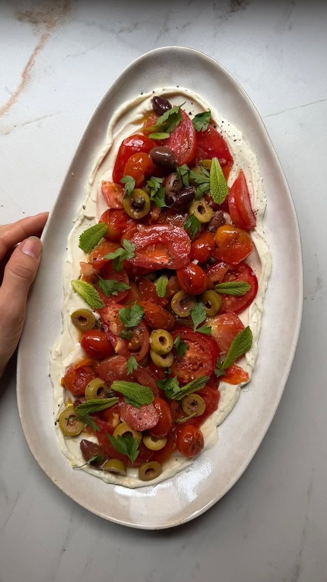 ENSALADA DE TOMATES Y LABNEH
.
Familia! Os traigo una ensalada un poco más compleja de lo habitual, pero increíblemente fácil y rica. Os va a hacer quedar muy bien cuando se la hagáis a vuestras personas favoritas.
.
La base es un labneh y sobre él va una ensalada de tomates y encurtidos ligeramente aliñada.
.
✔️Te cuento cómo hacer el LABNEH:
.
▫️4 yogures de soja naturales (que no estén endulzados)
▫️Sal al gusto
▫️1 cda de zumo de limón
▫️1/2 cdta de ajo en polvo
▫️1 cda de aceite de oliva
.
▪️Colocamos los yogures dentro de una bolsa de las de hacer leches vegetales (en su defecto, podemos usar una gasa de algodón o un colador de metal fino).
▪️Lo dejamos en un vaso o en un tarro ayudándonos de una gomilla para que quede en suspensión y lo llevamos a la nevera toda la noche (incluso más horas) para que vaya soltando poco a poco el suero. Al día siguiente, nos quedaremos con la parte densa y desecharemos el suero.
▪️Mezclamos el labneh con el resto de los ingredientes y listo.